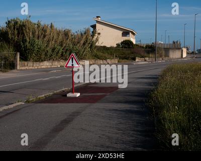 Ein Verkehrsschild, Ausrufezeichen. Warnschild mit Ausrufezeichen in rotem Dreieck auf einer Straße Stockfoto