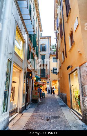 Verona, Italien - 24. August 2014: Blick auf die enge Straße im historischen Zentrum von Verona, Italien. Fassaden von Häusern in der Morgensonne. Stockfoto