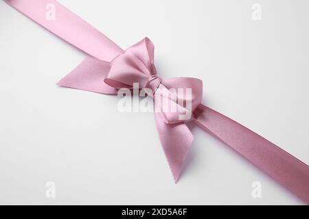 Rosa Satinband mit Bogen auf weißem Hintergrund Stockfoto