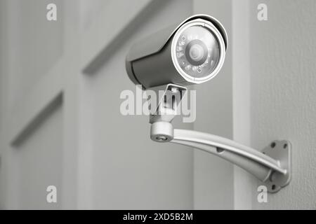 Moderne CCTV-Kamera an der Wand in Innenräumen, geringer Winkel Stockfoto