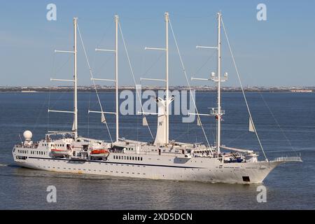 Der Luxus-Kreuzfahrtschoner Wind Star, der ihre Anlegestellen verrutscht hat, segelt den Fluss Tejo hinunter in Richtung Nordatlantik in der Nachmittagssonne, April 2024. Stockfoto