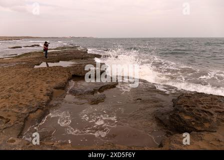 Ein Fotograf fotografiert die Wellen am Ufer des Kaspischen Meeres. Baku. Aserbaidschan. Stockfoto