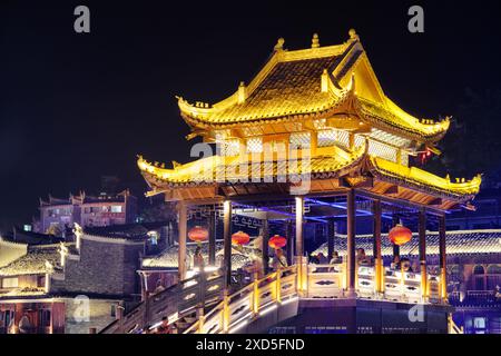 Fenghuang, China - 23. September 2017: Fabelhafter Blick auf die Brücke bei Nacht mit Elementen traditioneller chinesischer Architektur in der antiken Stadt Phoenix. Stockfoto