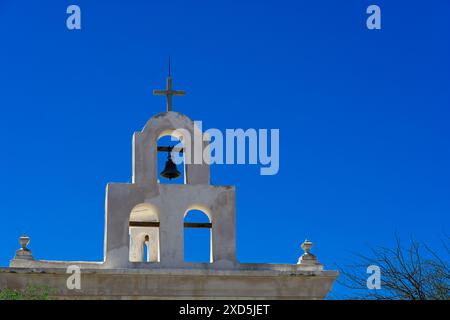 Glockenturm und Kreuz auf der Leichenkapelle neben der Missionskirche San Xavier del Bac Stockfoto