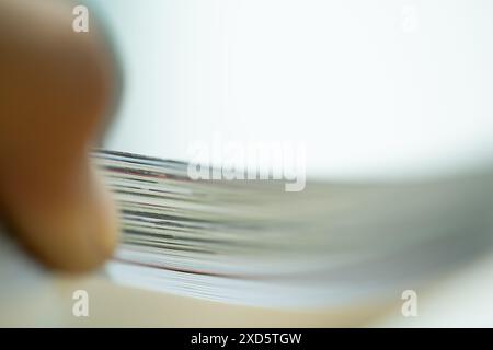 Nahaufnahme einer Person, die durch einen Stapel Papiere springt und einen unscharfen Bewegungseffekt erzeugt. Stockfoto