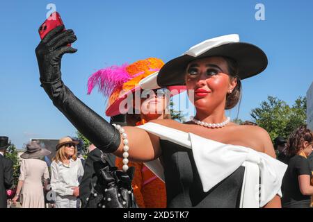 Ascot, Berkshire, Großbritannien. Juni 2024. Racegoers am Ladies Day (3. Tag) von Royal Ascot. Elegante Herren in formeller Kleidung und Damen, oft in Kleidern und ausgeklügelten Hutkreationen, können Sie sehen, wie sie ankommen und sich mischen, bevor Sie zu den Rennen gehen. Stockfoto