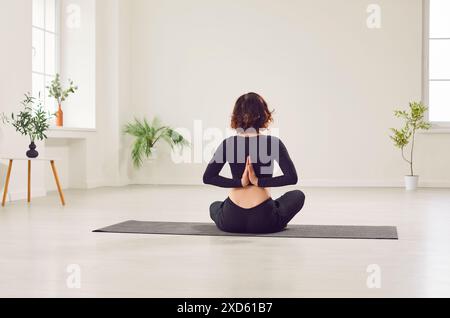 Yogi Fit Frau in Sportbekleidung, die Yoga-Übungen für Wirbelsäule, Schultern, Handgelenke macht, Namaste macht Stockfoto