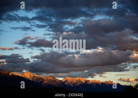 Ein Sonnenaufgang beleuchtet die Wolken und die Purcell Mountains über dem Lake Windermere in Invermere, British Columbia Stockfoto