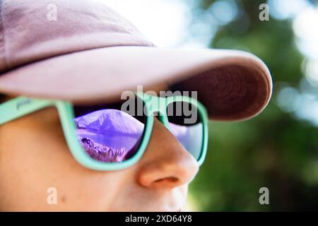 Eine Berglandschaft im Kananaskis Country ein beliebtes Wanderziel in Alberta, Kanada, spiegelt sich in der Sonnenbrille einer jungen Métis-Frau wider Stockfoto