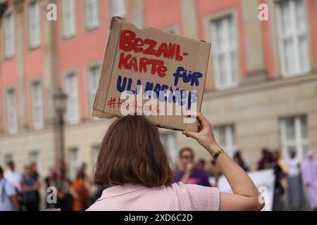 Eine Demonstrantin mit Schild Bezahlkarte für Uli Hoeneß während einer Demonstration gegen Abschiebungen anlässlich der Innenministerkonferenz IMK in Potsdam, 20. Juni 2024. Demonstration gegen Abschiebungen in Potsdam *** Demonstration gegen Abschiebungen in Potsdam, 20. Juni Demonstration gegen Abschiebungen in Potsdam mit einem Schild mit einer Zahlungskarte für Uli Hoeneß während einer Demonstration gegen Abschiebungen anlässlich der Konferenz der Innenminister IMK in Potsdam, 20. Juni 2024 Demonstration gegen Abschiebungen in Potsdam Stockfoto