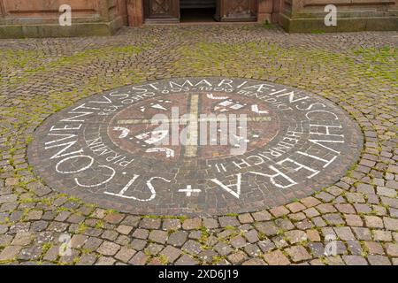 Friesenheim, Deutschland - 29. April 2023: Kreisförmiger Mosaikpflaster mit Kreuzdesign und Inschrift vor dem St. Marien Kloster in Deutschland. Stockfoto