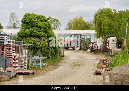 Eine vernachlässigte, unbefestigte Straße, die auf beiden Seiten mit diversen Schrottgegenständen bestückt ist, schafft eine unordentliche und ungepflegte Umgebung. Stockfoto