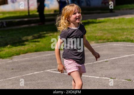 Ein junges Mädchen spielt ein Spiel an einem sonnigen Tag in einem Park Stockfoto