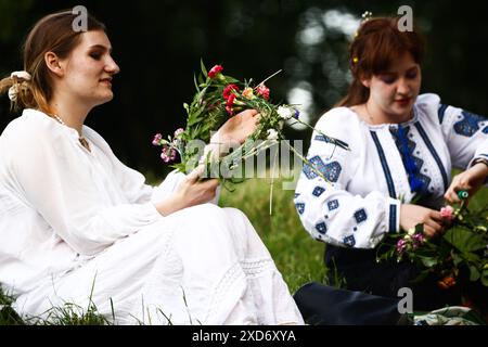 Krakau, Polen. Juni 2024. Mädchen machen Kränze, während sie die Sommersonnenwende während der „Kupala-Nacht“ am Krakushügel in Krakau, Polen, am 20. Juni 2024 feiern. Die KupaÅ‚a Night ist ein altslawischer Feiertag, der auf die kürzeste Nacht des Jahres fällt. In dieser Nacht wurden Rituale wie das Sammeln und Herstellen von Kronen aus Kräutern und Wildblumen von Mädchen und jungen Frauen durchgeführt, Girlanden auf dem Wasser schickten, Feuer anzünden, tanzen, singen und über Feuer springen. (Kreditbild: © Beata Zawrzel/ZUMA Press Wire) NUR REDAKTIONELLE VERWENDUNG! Nicht für kommerzielle ZWECKE! Stockfoto