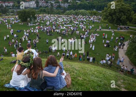 Krakau, Polen. Juni 2024. Die Teilnehmer feiern die Sommersonnenwende während der „Kupala-Nacht“ am Krakus-Hügel in Krakau, Polen am 20. Juni 2024. Die KupaÅ‚a Night ist ein altslawischer Feiertag, der auf die kürzeste Nacht des Jahres fällt. In dieser Nacht wurden Rituale wie das Sammeln und Herstellen von Kronen aus Kräutern und Wildblumen von Mädchen und jungen Frauen durchgeführt, Girlanden auf dem Wasser schickten, Feuer anzünden, tanzen, singen und über Feuer springen. (Kreditbild: © Beata Zawrzel/ZUMA Press Wire) NUR REDAKTIONELLE VERWENDUNG! Nicht für kommerzielle ZWECKE! Stockfoto