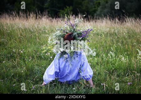 Krakau, Polen. Juni 2024. Ein Mädchen mit Blumenkranz feiert die Sommersonnenwende während der „Kupala-Nacht“ am Krakushügel in Krakau, Polen am 20. Juni 2024. Die KupaÅ‚a Night ist ein altslawischer Feiertag, der auf die kürzeste Nacht des Jahres fällt. In dieser Nacht wurden Rituale wie das Sammeln und Herstellen von Kronen aus Kräutern und Wildblumen von Mädchen und jungen Frauen durchgeführt, Girlanden auf dem Wasser schickten, Feuer anzünden, tanzen, singen und über Feuer springen. (Kreditbild: © Beata Zawrzel/ZUMA Press Wire) NUR REDAKTIONELLE VERWENDUNG! Nicht für kommerzielle ZWECKE! Stockfoto