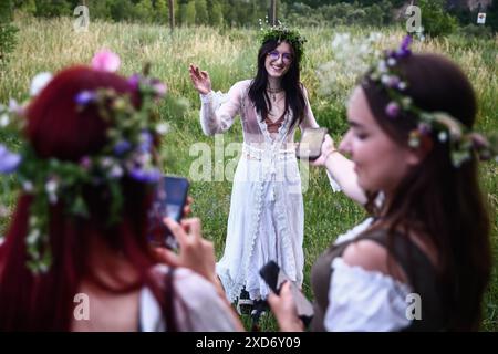 Krakau, Polen. Juni 2024. Die Teilnehmer feiern die Sommersonnenwende während der „Kupala-Nacht“ am Krakus-Hügel in Krakau, Polen am 20. Juni 2024. Die KupaÅ‚a Night ist ein altslawischer Feiertag, der auf die kürzeste Nacht des Jahres fällt. In dieser Nacht wurden Rituale wie das Sammeln und Herstellen von Kronen aus Kräutern und Wildblumen von Mädchen und jungen Frauen durchgeführt, Girlanden auf dem Wasser schickten, Feuer anzünden, tanzen, singen und über Feuer springen. (Kreditbild: © Beata Zawrzel/ZUMA Press Wire) NUR REDAKTIONELLE VERWENDUNG! Nicht für kommerzielle ZWECKE! Stockfoto