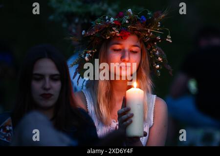 Krakau, Polen. Juni 2024. Ein Mädchen mit einem Blumenkranz feiert die Sommersonnenwende während der „Kupala-Nacht“ am Krakushügel in Krakau, Polen am 20. Juni 2024. Die KupaÅ‚a Night ist ein altslawischer Feiertag, der auf die kürzeste Nacht des Jahres fällt. In dieser Nacht wurden Rituale wie das Sammeln und Herstellen von Kronen aus Kräutern und Wildblumen von Mädchen und jungen Frauen durchgeführt, Girlanden auf dem Wasser schickten, Feuer anzünden, tanzen, singen und über Feuer springen. (Kreditbild: © Beata Zawrzel/ZUMA Press Wire) NUR REDAKTIONELLE VERWENDUNG! Nicht für kommerzielle ZWECKE! Stockfoto