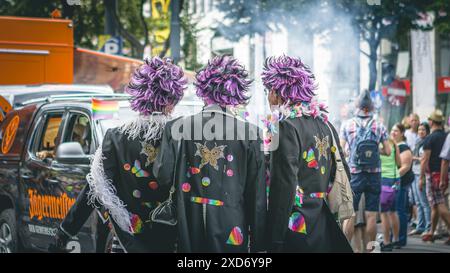 3 Männer mit violetten Perücken bei der Pride Parade, fotografiert von hinten, Wien, Österreich Stockfoto