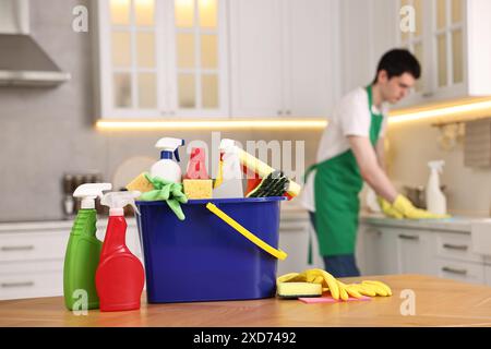 Professioneller Hausmeister, der in der Küche arbeitet, konzentriert sich auf Eimer mit Zubehör. Reinigungsservice Stockfoto