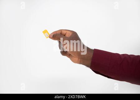 Schwarze Hand hält gelbe SIM-Karte über weißem Hintergrund Stockfoto