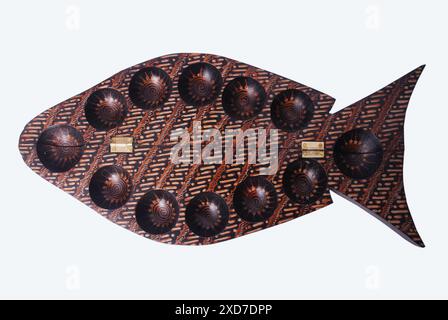 Congklak oder Dakon ist in Form eines Fisches mit Batik verziert, einem traditionellen Spielinstrument, das ursprünglich aus dem Nahen Osten stammt Stockfoto