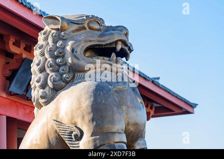 Erstaunliche Statue des mystischen chinesischen Schutzlöwen auf rotem Dach Hintergrund in der Altstadt von Dali, Provinz Yunnan, China. Stockfoto