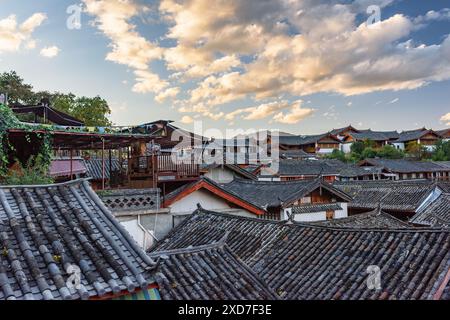 Traditionelle chinesische schwarze Ziegeldächer mit authentischen Häusern in der Altstadt von Lijiang, China. Fantastischer Blick auf den farbenfrohen Sonnenuntergang. Stockfoto