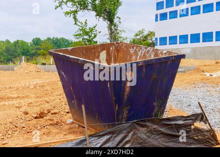 Beim Bau eines Hauses werden Bauabfälle in Abfallbehältern aus Metall entsorgt Stockfoto