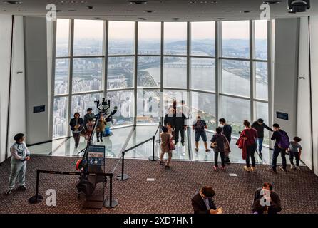 Seoul, Südkorea - 13. Oktober 2017: Blick von oben auf Touristen, die Fotos auf dem transparenten Glasboden der Aussichtsplattform des Seoul Sky machen. Stockfoto