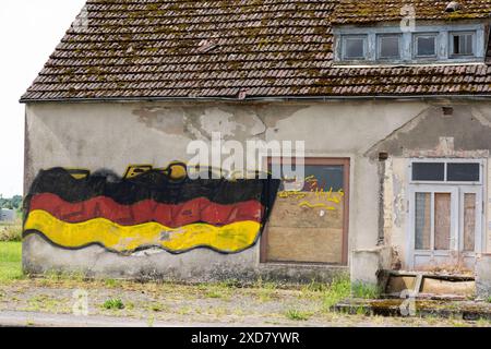 Eine Hausruine mit einer angemalten Deutschlandfahne an der Fassade steht an einer Bundesstraße in Vorpommern. Anklam *** Eine Ruine mit gemalter deutscher Flagge an der Fassade steht an einer Hauptstraße in Anklam, Vorpommern Copyright: FrankxHormannx/xnordlicht Stockfoto