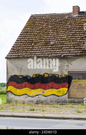 Eine Hausruine mit einer angemalten Deutschlandfahne an der Fassade steht an einer Bundesstraße in Vorpommern. Anklam *** Eine Ruine mit gemalter deutscher Flagge an der Fassade steht an einer Hauptstraße in Anklam, Vorpommern Copyright: FrankxHormannx/xnordlicht Stockfoto