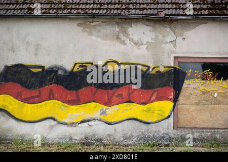 Eine Hausruine mit einer angemalten Deutschlandfahne an der Fassade steht an einer Bundesstraße in Vorpommern. Anklam *** Eine Ruine mit gemalter deutscher Flagge an der Fassade steht an einer Hauptstraße in Anklam, Vorpommern Copyright: FrankxHormannx/xnordlicht Stockfoto