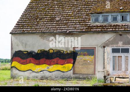 Eine Hausruine mit einer angemalten Deutschlandfahne an der Fassade steht an einer Bundesstraße in Vorpommern. Anklam *** Eine Ruine mit gemalter deutscher Flagge an der Fassade steht an einer Hauptstraße in Anklam, Vorpommern Copyright: FrankxHormannx/xnordlicht Stockfoto