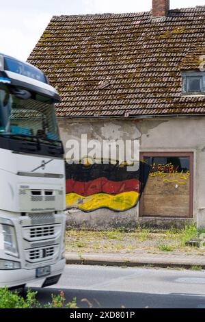 Eine Hausruine mit einer angemalten Deutschlandfahne an der Fassade steht an einer Bundesstraße in Vorpommern. Anklam *** Eine Ruine mit gemalter deutscher Flagge an der Fassade steht an einer Hauptstraße in Anklam, Vorpommern Copyright: FrankxHormannx/xnordlicht Stockfoto