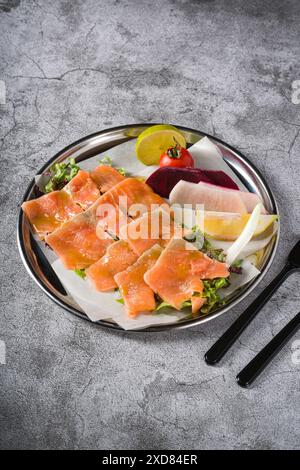 Räucherlachs mit Gemüse darunter auf einem Steintisch Stockfoto
