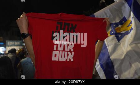 JERUSALEM – 20. JUNI: ein Demonstrant hält ein T-Shirt mit dem Text "du bist der Anführer, du bist schuldig" (in Bezug auf Premierminister Netanjahu) hoch, während regierungsfeindliche Demonstranten während einer Demonstration in der Nähe der Privatresidenz des Premierministers gegen die Regierung Netanjahus und der Forderung nach Neuwahlen am 20. Juni 2024 in Jerusalem Slogans singen. Israel Stockfoto