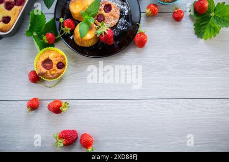 Süße Quark-Muffins mit Erdbeerfüllung, auf einem Teller auf einem Holztisch. Stockfoto