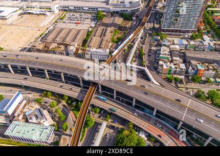 Mehrstöckiger Kreuzungsübergang zwischen Autobahn, Schnellstraße und elektrischer S-Bahn-Bahn in städtischen Gebieten mit Draufsicht. Stockfoto