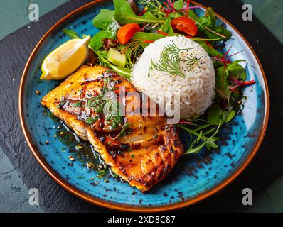 Gegrillter Fisch mit Reis und Salat auf moderner Keramikplatte Stockfoto