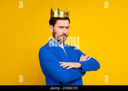 Foto-Porträt des gutaussehenden jungen Mannes arrogant strenger König gekleidet stilvolles blaues Kleid isoliert auf gelbem Hintergrund Stockfoto