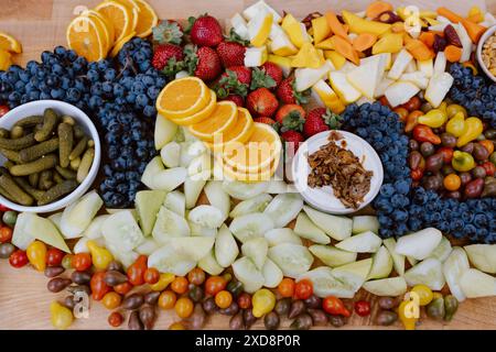 Buntes Weidebrett mit frischem Obst, Gemüse und Gurken. Stockfoto
