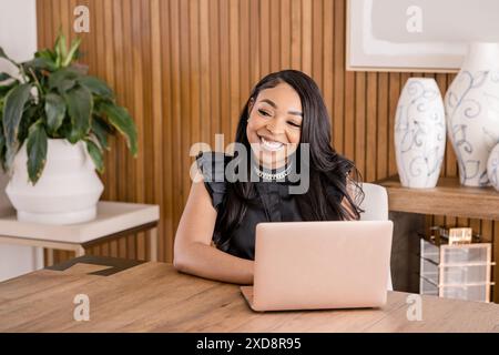 Frau, die am Schreibtisch im Büro mit einem Laptop arbeitet Stockfoto