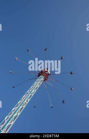 Schaukelfahrt in großer Höhe gegen den blauen Himmel in einem Vergnügungspark. Stockfoto