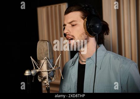 Ein Mann gießt sein Herz aus, während er in einem Aufnahmestudio während einer Musikbandprobe in ein Mikrofon singt. Stockfoto