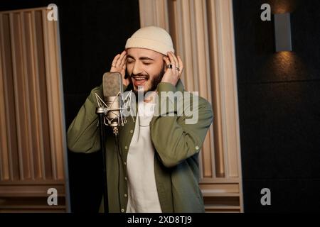 Ein Mann singt leidenschaftlich in ein Mikrofon in einem Aufnahmestudio während einer Musikbandprobe. Stockfoto