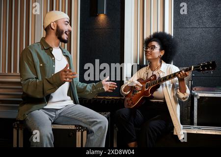 Ein Mann und eine Frau spielen leidenschaftlich Gitarren in einem Aufnahmestudio und kreieren zusammen fesselnde Musik. Stockfoto