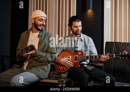 Zwei Männer spielen leidenschaftlich Gitarre in einem Aufnahmestudio während einer Musikbandprobe. Stockfoto