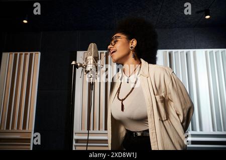 Eine Frau, die während einer Musikbandprobe in einem Aufnahmestudio leidenschaftlich in ein Mikrofon singt. Stockfoto
