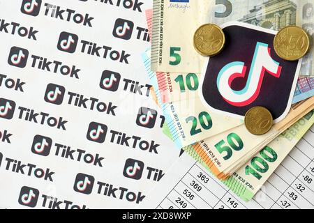 KIEW, UKRAINE - 20. APRIL 2024 TikTok-Logo und viele Euro-Geldscheine. Symbol der berühmten Plattform des sozialen Netzwerks und der europäischen Geldscheine aus nächster Nähe Stockfoto